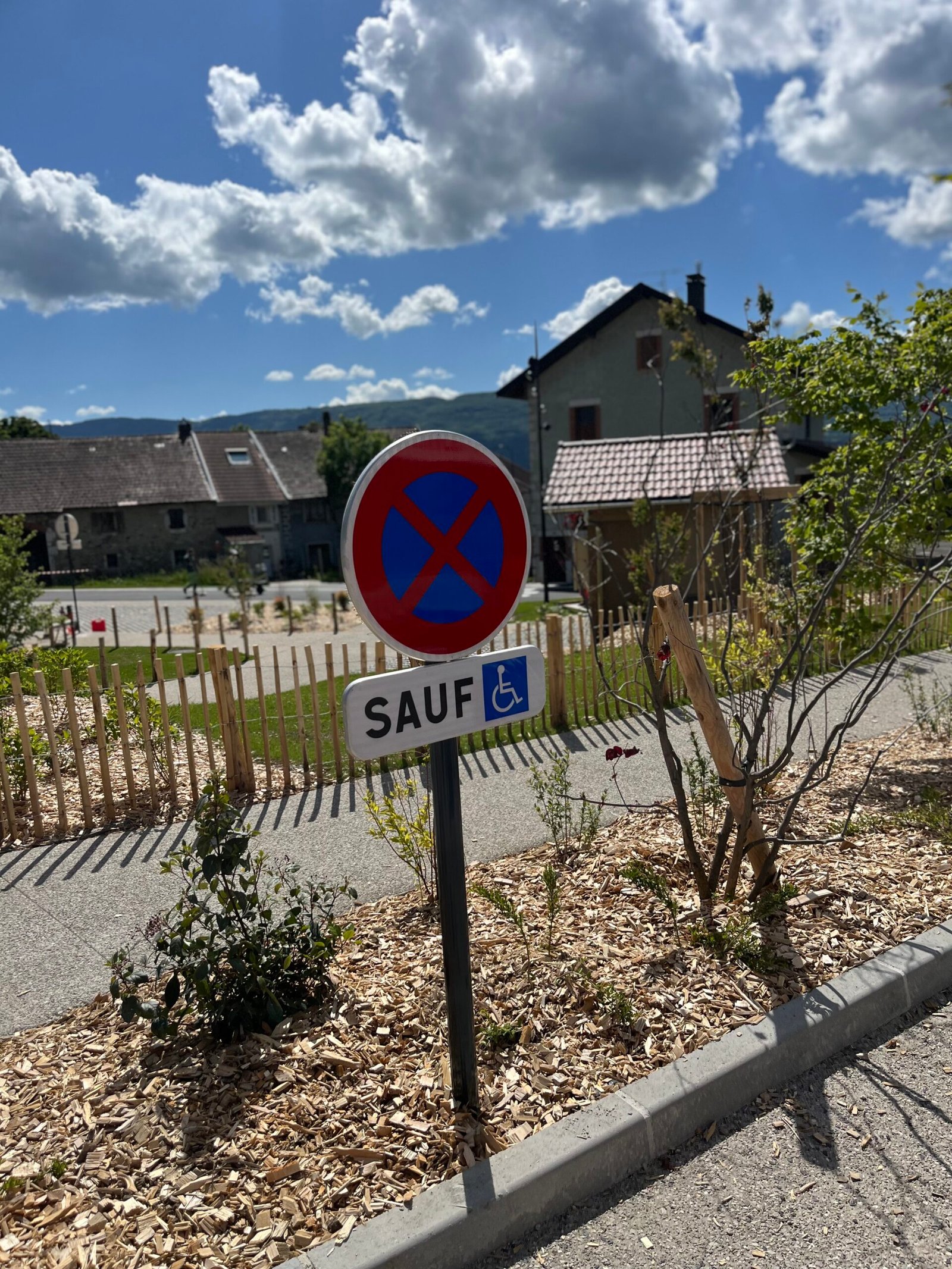 Panneau de signalisation routière Savoie posé sur mât, ancrage béton visible