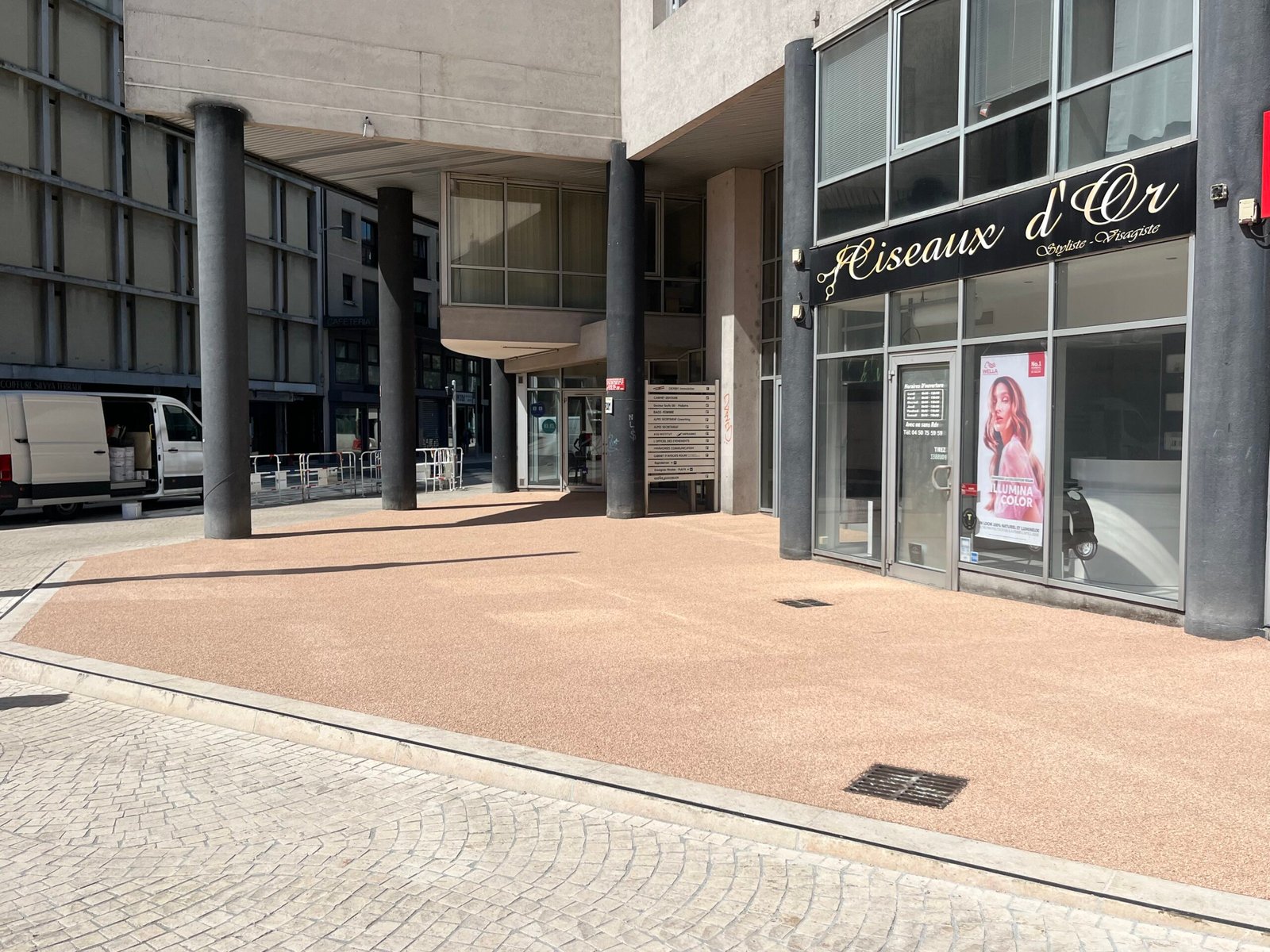 Devant de commerce habillé en résine gravillonnée, plusieurs enrobés hétérogènes recouverts en Savoie